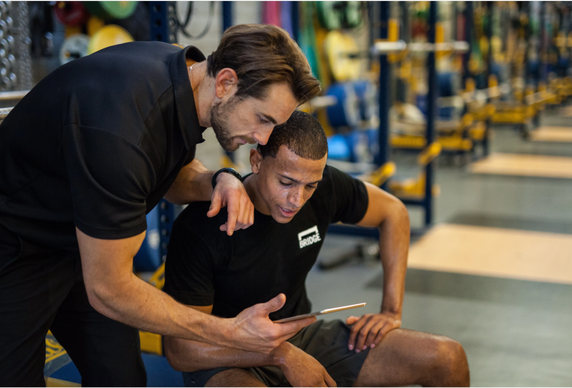 BridgeAthletic coach reviewing performance data with an athlete